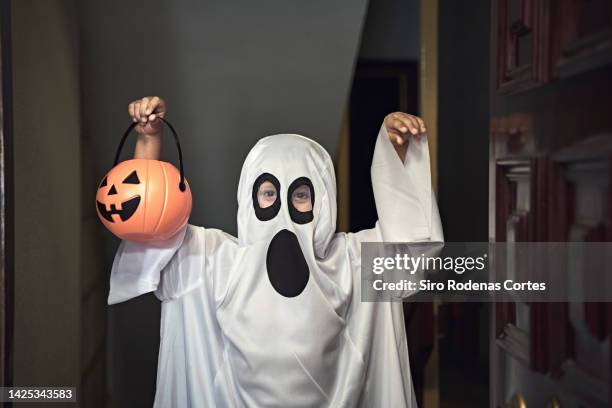 trick or treat; little boy dressed as a ghost - halloween kid stock-fotos und bilder