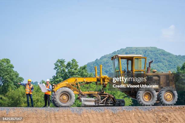 civil engineer planning with floor plan on the construction site in road construction. - niveleuse photos et images de collection
