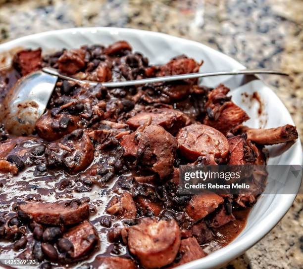 brazilian feijoada, beans and pork, is served ready to eat. viewed from above. - brazilian feijoada dish stock-fotos und bilder