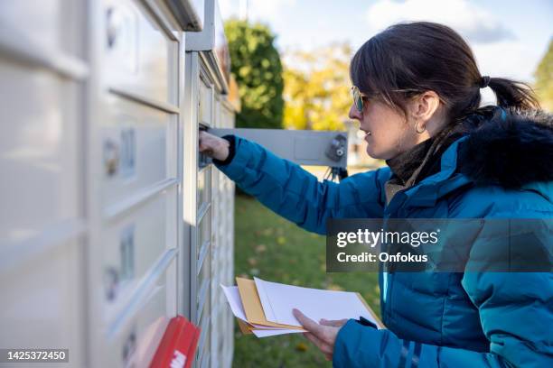 woman collecting post at home at the mailbox in autumn, quebec, canada - picking up mail stock pictures, royalty-free photos & images