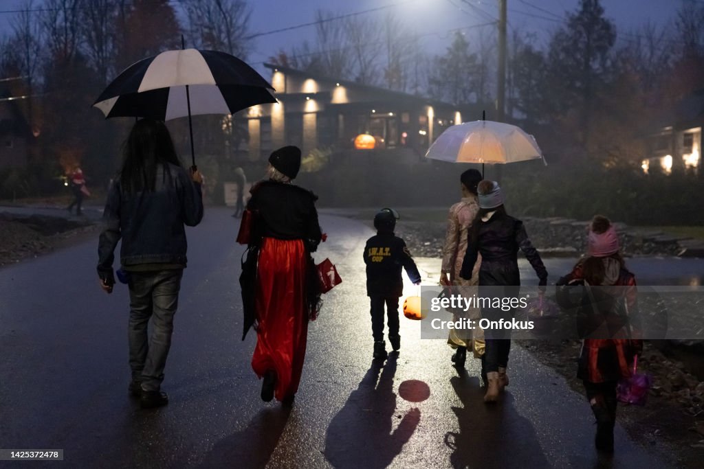 Group of People walking on illuminated street on Halloween night