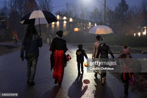 group of people walking on illuminated street on halloween night - bus eller godis bildbanksfoton och bilder