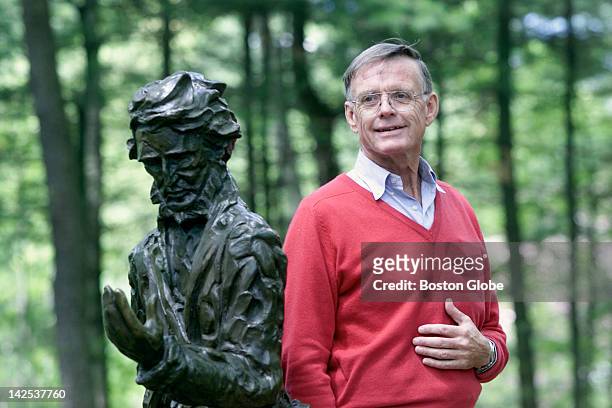 Robert D. Richardson, author on Henry David Thoreau and Ralph Waldo Emerson, stands by a statue of Thoreau at Walden Pond Reservation.
