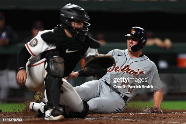 Spencer Torkelson of the Detroit Tigers scores a run in front of catcher Adley Rutschman of the Baltimore Orioles during the seventh inning at Oriole...
