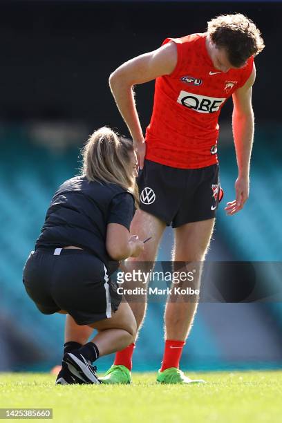 Nick Blakey receives attention from the trainer during a Sydney Swans AFL training session at Sydney Cricket Ground on September 20, 2022 in Sydney,...