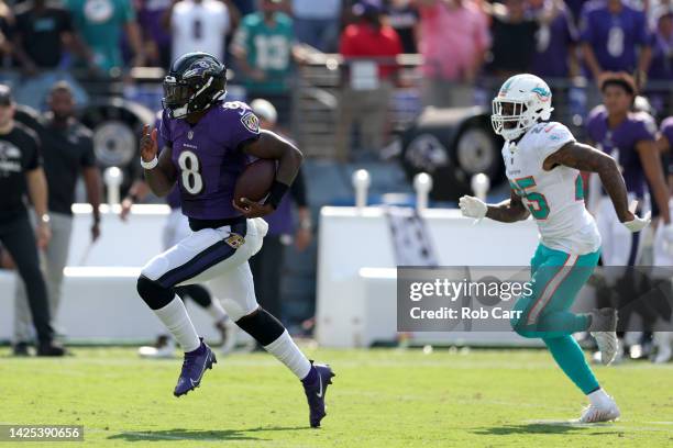 Quarterback Lamar Jackson of the Baltimore Ravens runs for a fourth quarter touchdown in front of cornerback Xavien Howard of the Miami Dolphins at...