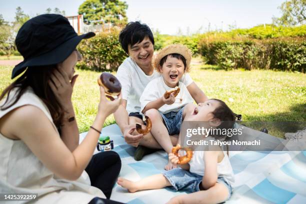 a japanese family enjoying a picnic in a park in spring. - family at a picnic ストックフォトと画像