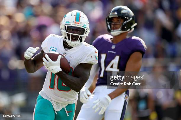 Wide receiver Tyreek Hill of the Miami Dolphins catches a second half touchdown pass in front of safety Kyle Hamilton of the Baltimore Ravens at M&T...