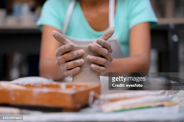 young woman is making pottery as leisure activity. - art and craft product stock pictures, royalty-free photos & images