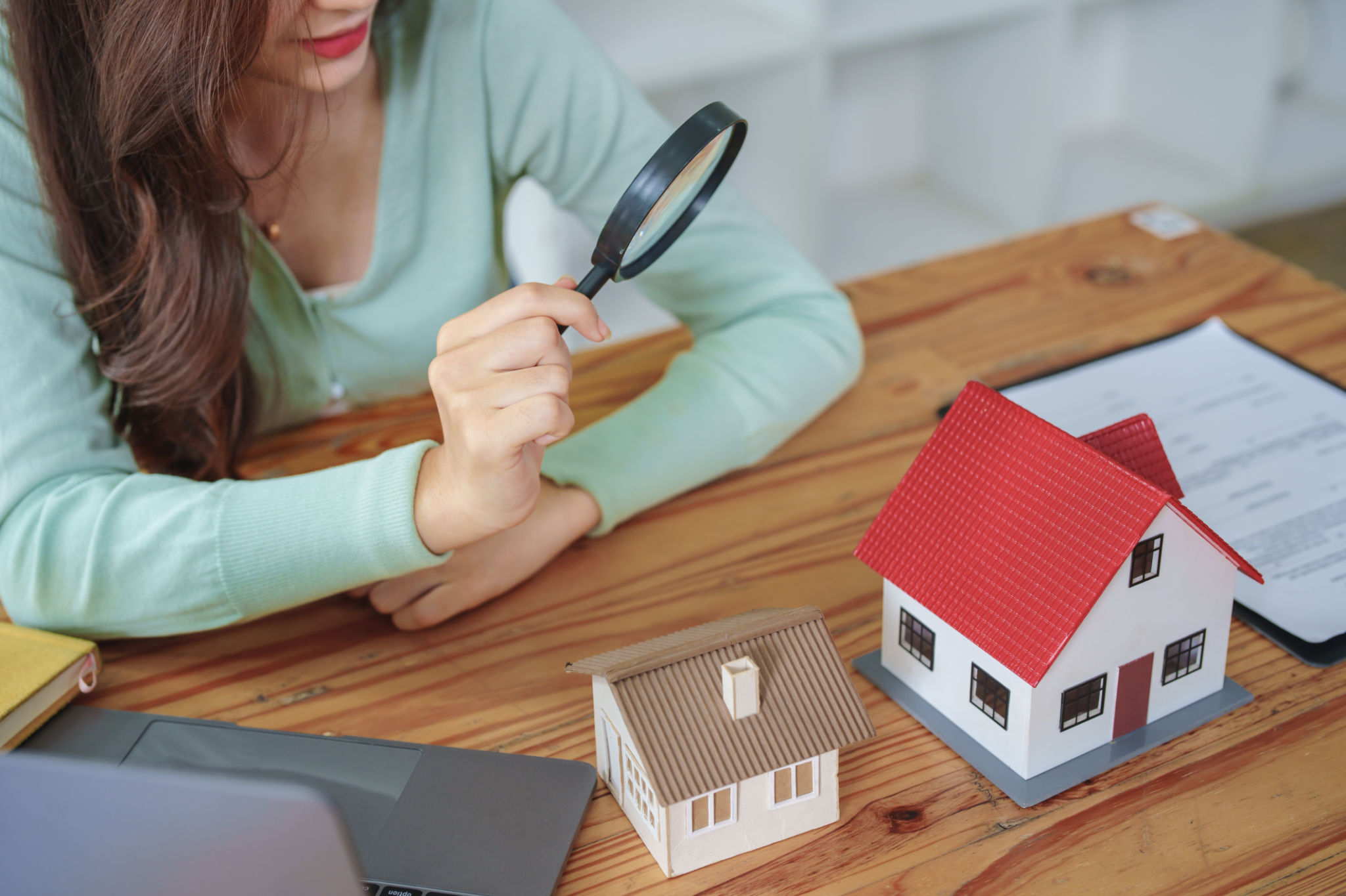 Customer holding a magnifying glass to select a house model, residential inspection concept Customer holding a magnifying glass to select a house model, residential inspection concept