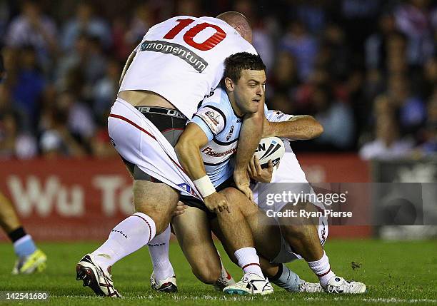 Nathan Gardner of the Sharks is tackled by Michael Weyman of the Dragons during the round six NRL match between the Cronulla Sharks and the St George...