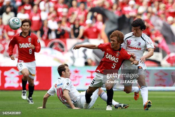 Shunki Takahashi of Urawa Red Diamonds competes for the ball against Kim Bo-kyung and Luis Fernando Martinez of Cerezo Osaka during the J.League J1...