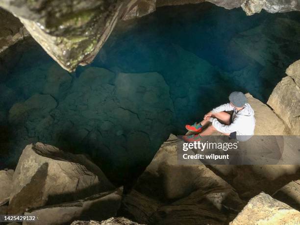 sitting at grjótagjá thermal spring - grjótagjá cave stock pictures, royalty-free photos & images