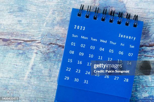 top view of the calendar desk 2023: january is the month for the organizer to plan and deadline with an old grunge wood background. - flight time stock pictures, royalty-free photos & images