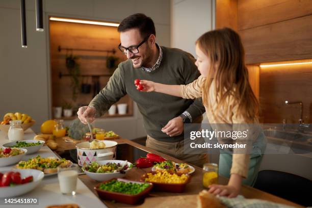 glücklicher alleinerziehender vater und tochter beim zubereiten von speisen in der küche. - generationen kochen stock-fotos und bilder
