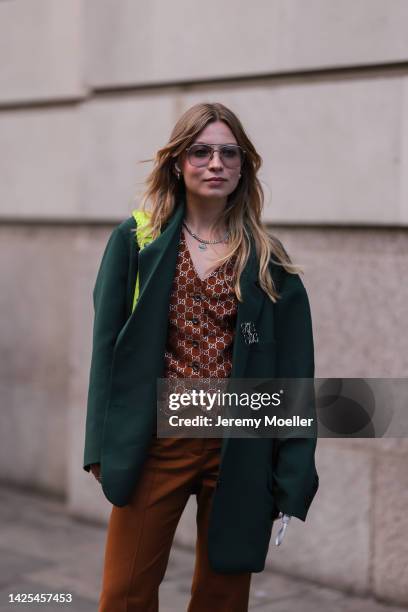 Fashion week guest seen wearing a gucci vest and a neon balenciaga le cagole bag, outside poster girl during London Fashion Week September 2022 on...