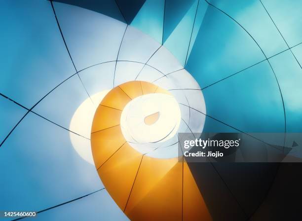 spiral staircase illuminated by neon light at night - light architecture foto e immagini stock