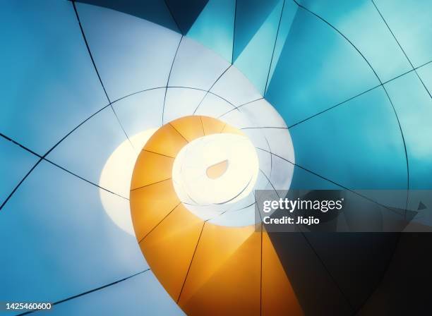 spiral staircase illuminated by neon light at night - dynamic architecture stock pictures, royalty-free photos & images