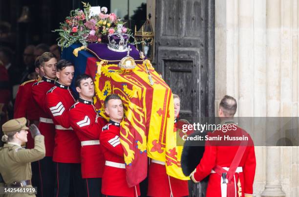 The coffin of Queen Elizabeth II with the Imperial State Crown resting on top is carried by the Bearer Party as it departs Westminster Abbey during...