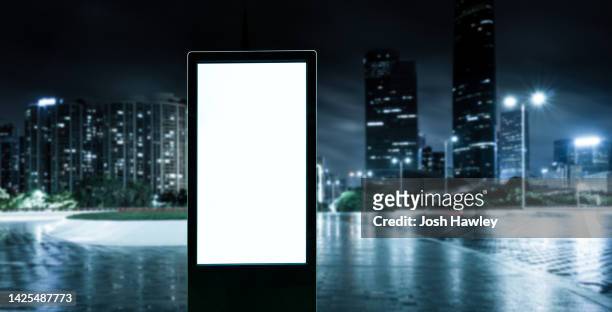 blank billboards on city streets - billboard night photos et images de collection