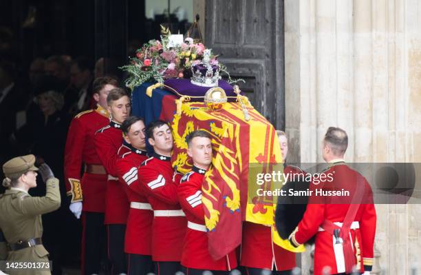 The coffin of Queen Elizabeth II with the Imperial State Crown resting on top is carried by the Bearer Party as it departs Westminster Abbey during...