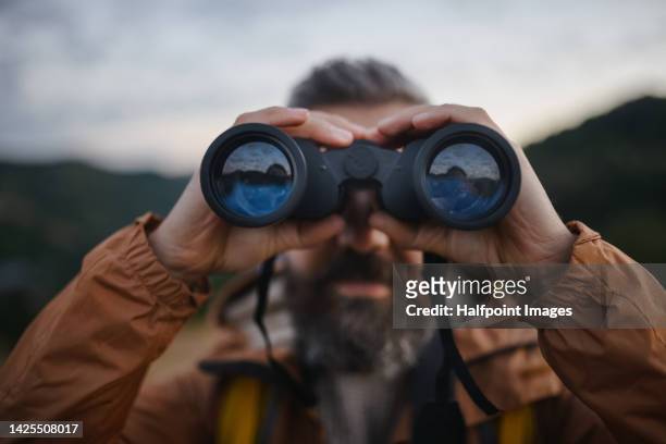 portrait of man looking trough binoculars. - spy glass stock pictures, royalty-free photos & images