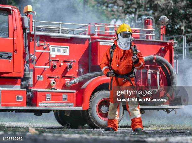 firefighter prepare equipment for emergency situation and fire engine. - fire engine ストックフォトと画像