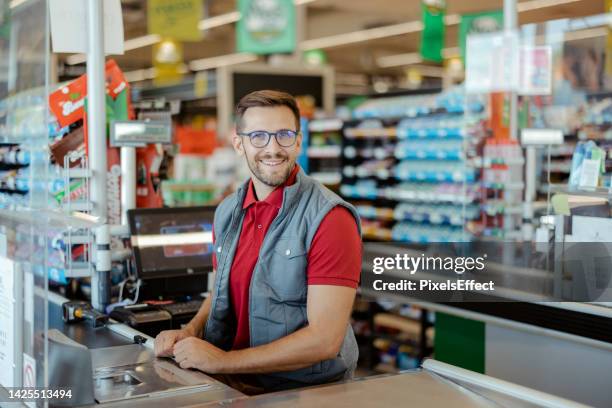 shopkeeper looking at camera - assistant imagens e fotografias de stock