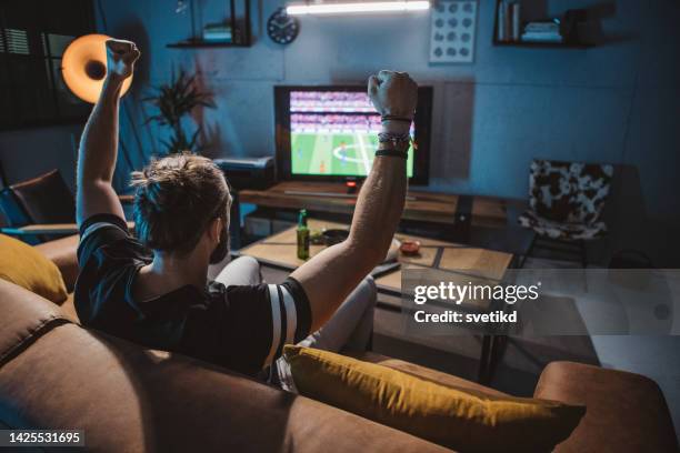 watching soccer game at home - vrijetijd sport en spel stockfoto's en -beelden