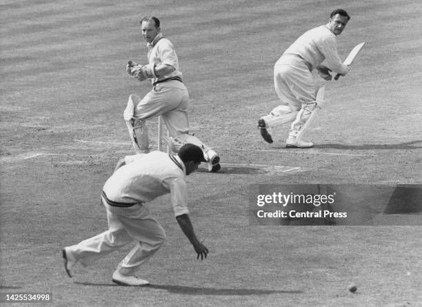 Surrey County Cricket Club Wicketkeeper Arthur McIntyre looks on from behind the stumps as Norman "Buddy" Oldfield , right handed batter for...