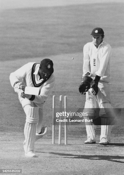 England wicketkeeper Alan Knott looks on as batsman Clive Lloyd from Guyana and left-handed batsman for the Rest of the World XI cricket team is...