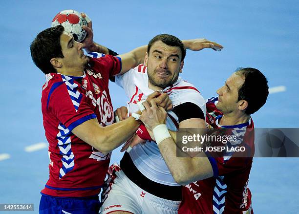 Serbia's Nikola Manojlovic and Alem Toskic vie with Poland's Bartosz Jurecki during the handball pre-Olympic qualifying match Serbia vs Poland on...