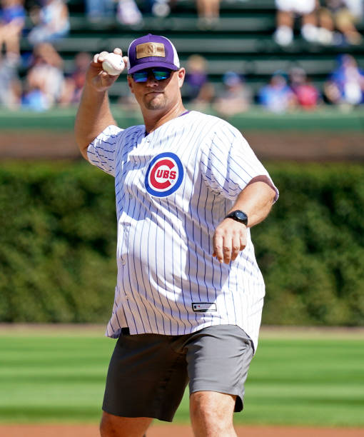 Northwestern baseball head coach Jim Foster throws the ceremonial first pitch of the game between the Chicago Cubs and the Colorado Rockies at...