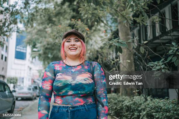 portrait asiatique multiracial lgbtq jeune femme regardant la caméra souriant debout sur la passerelle piétonne - large photos et images de collection