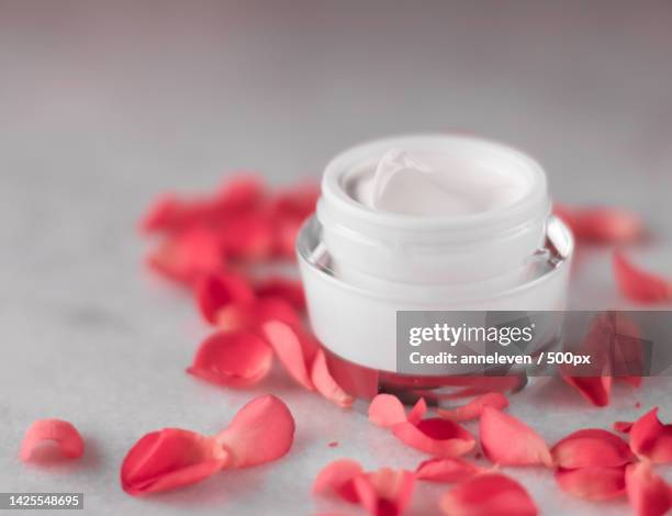 luxe face cream and rose petals - cosmetics with flowers styled beauty - protection luxe stock pictures, royalty-free photos & images