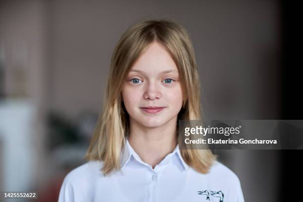 portrait of a 13-year-old girl with blond hair and blue eyes looking into the camera - 12 year old blonde girl ストックフォトと画像