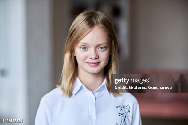 portrait of a 13-year-old girl with blond hair and blue eyes looking into the camera - 12 year old blonde girl ストックフォトと画像