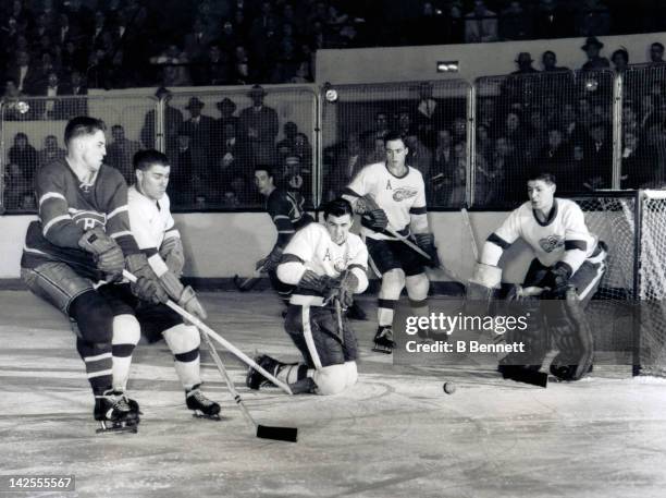 Jean Beliveau of the Montreal Canadiens goes for the puck as Barry Cullen, goalie Terry Sawchuk, Red Kelly and Alex Delvecchio of the Detroit Red...