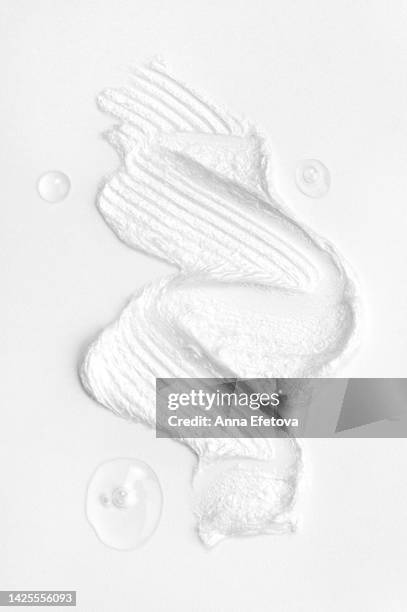 three drops of a tonic and textured white cream on white background. beauty products based on polyglutamic acid, ceramides and many vitamins. macrophotography from above - nata fotografías e imágenes de stock