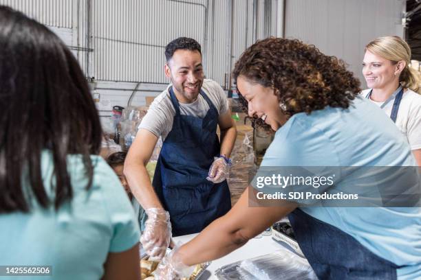 coworkers volunteer at the food drive - homeless shelter man stock pictures, royalty-free photos & images