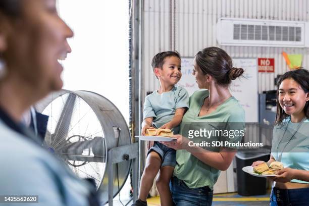 young mother and son smile at each other - homeless shelter stock pictures, royalty-free photos & images