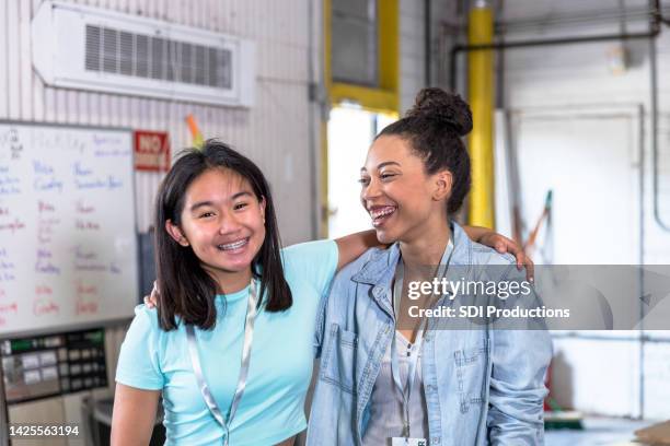 mientras se ofrecen como voluntarias, las hermanas se paran con los brazos uno alrededor del otro - niece fotografías e imágenes de stock