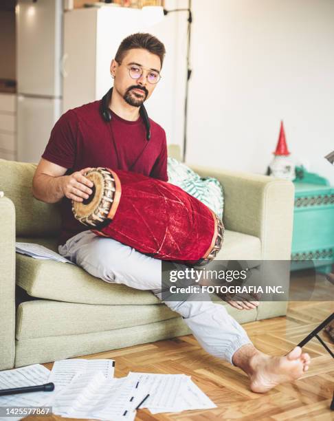 young male musician practising tabla at home - tabla stock pictures, royalty-free photos & images