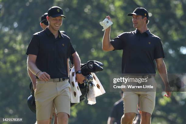 Cam Davis of Australia and the International Team and Adam Scott of Australia and the International Team walk together during a practice round prior...