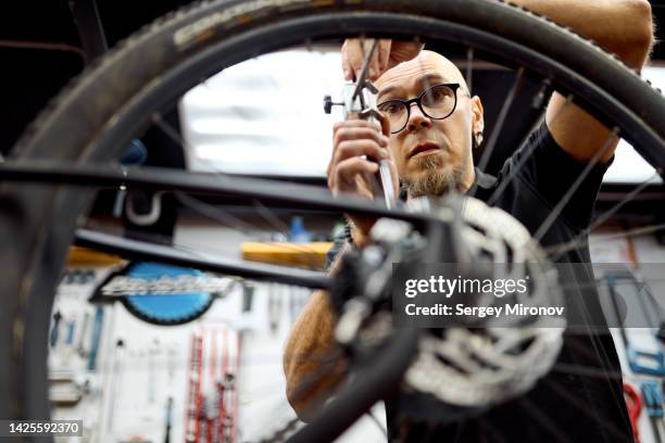 man repairing and tuning bicycle at workshop - personal perspective or pov stock-fotos und bilder