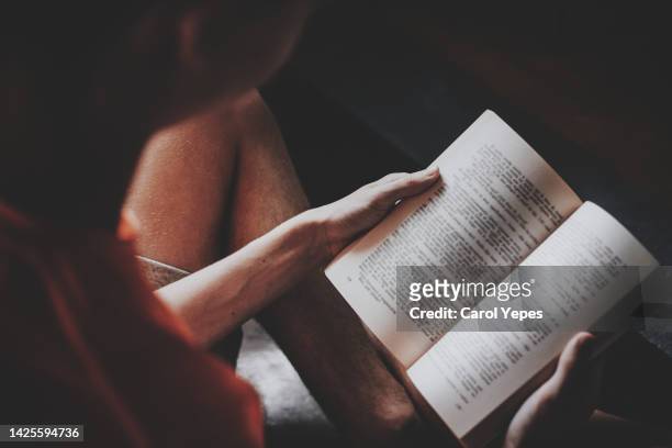 hispanic boy in eyeglasses reading a book at living room - student reading book stockfoto's en -beelden