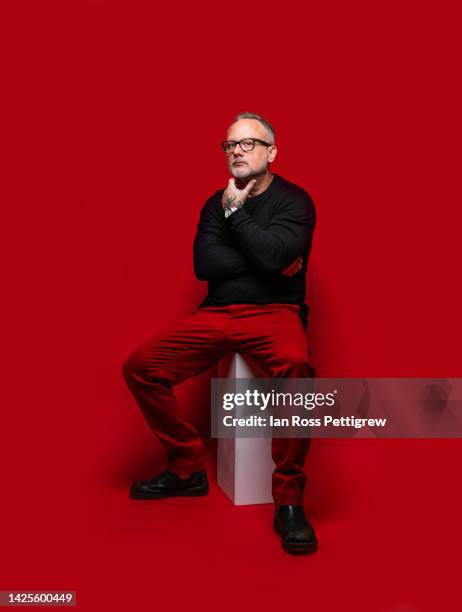 middle-aged man on red background - red pants stock-fotos und bilder