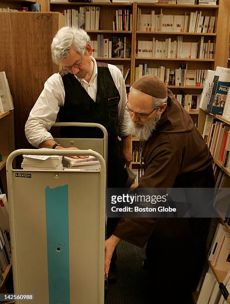 Manager Rupert Davis, left, works with Father Paul of Jesus, head of the store's French Department working at Schoenhof's Foreign Books in Harvard...