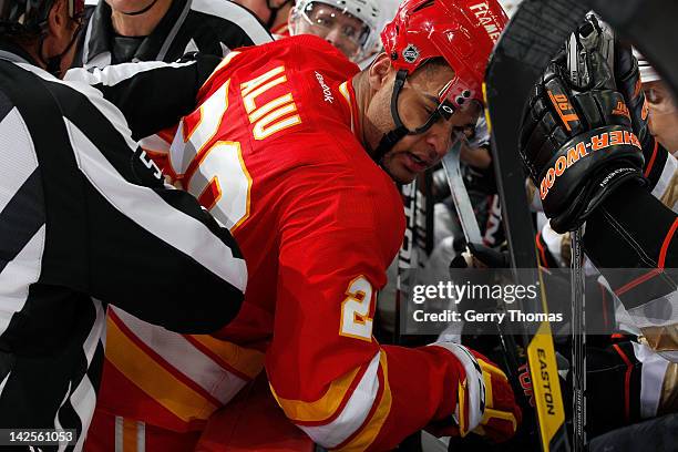 Akim Aliu of the Calgary Flames is checked against the boards during the game against the Anaheim Ducks on April 7, 2012 at the Scotiabank Saddledome...