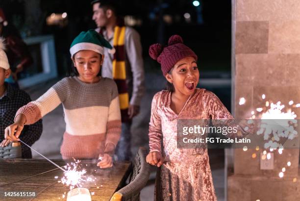 sisters celebrating christmas with sparklers - sparklers stock pictures, royalty-free photos & images